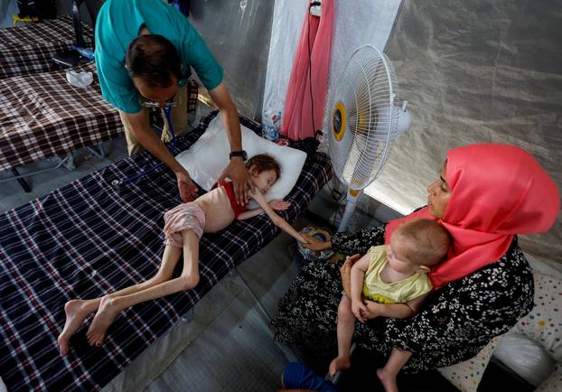 FILE PHOTO: Malnourished Palestinian children receive treatment at the IMC field hospital in Deir Al-Balah, central Gaza Strip