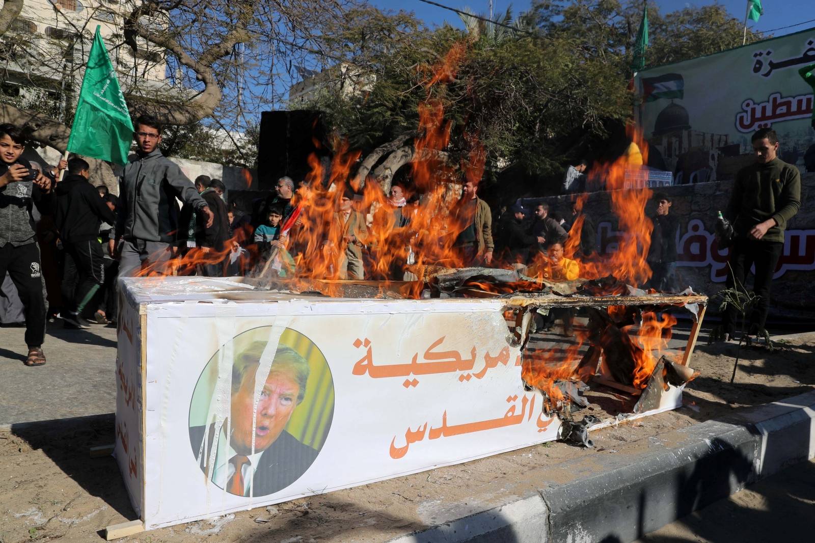 Palestinian Hamas supporters burn a model of a coffin representing the U.S. embassy in Jerusalem with a picture of U.S. President Donald Trump, during a rally in Gaza