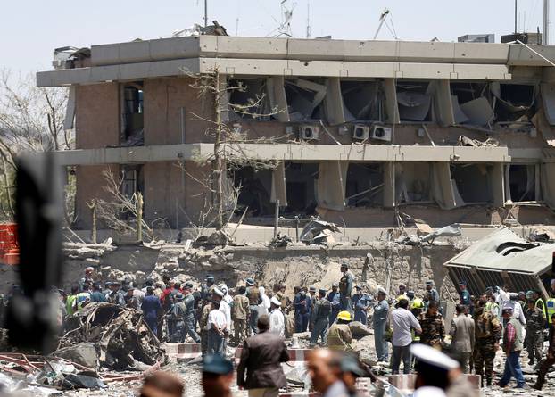 Afghan officials inspect outside the German embassy after a blast in Kabul, Afghanistan