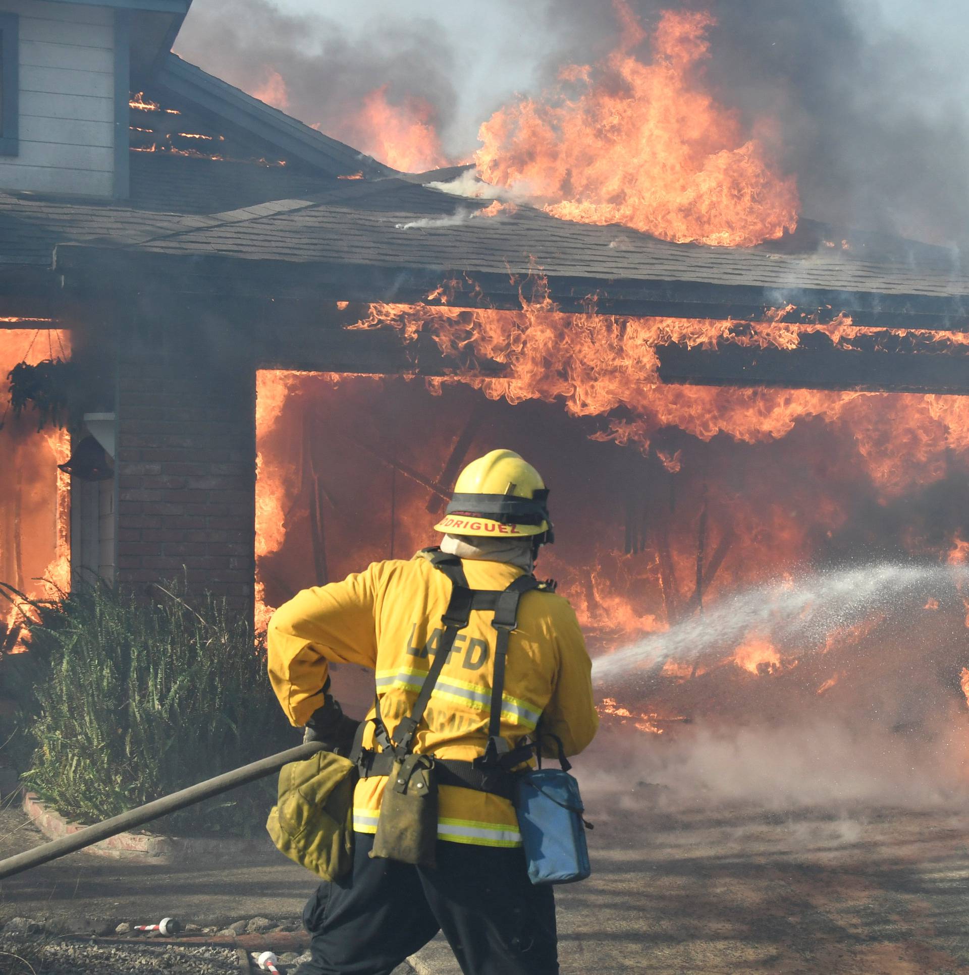 Firefighters battle to save one of many homes burning in an early-morning Creek Fire that broke out in the Kagel Canyon area in the San Fernando Valley north of Los Angeles