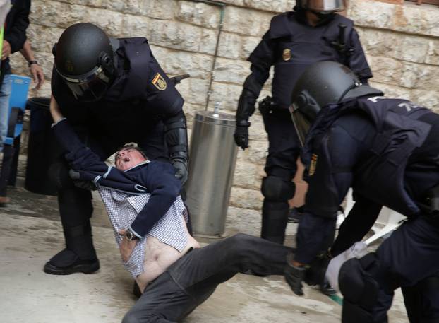 Spanish police scuffle with a man outside a polling station for the banned independence referendum in Tarragona