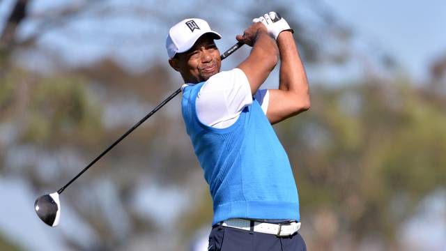 FILE PHOTO: Tiger Woods tees off the 5th hole during the first round of the Farmers Insurance Open golf tournament in La Jolla