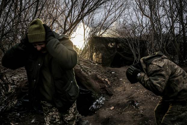 Ukrainian servicemen fire a self-propelled howitzer towards Russian troops at a frontline near the town of Chasiv Yar