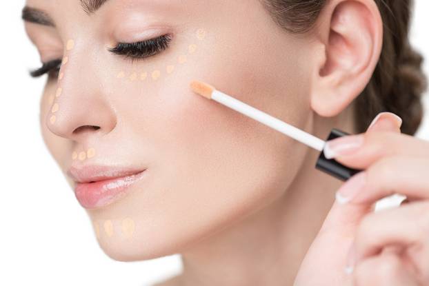 Attractive young lady using make-up brush