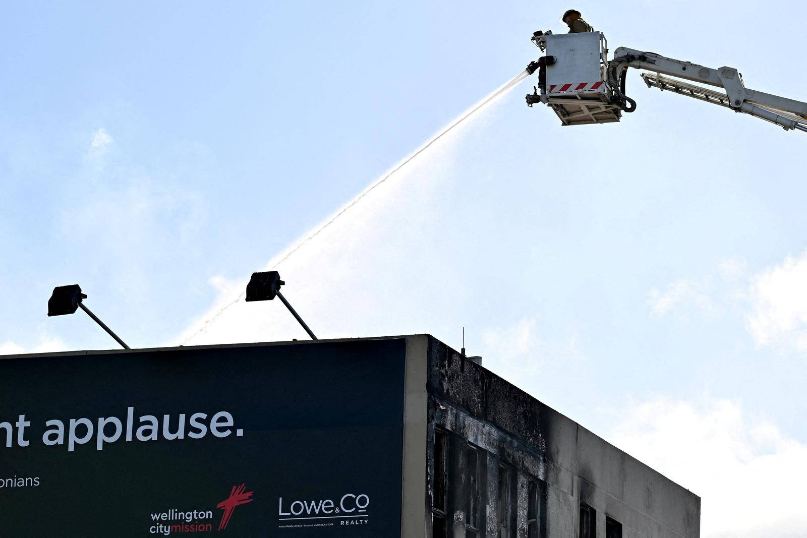 Firefighters work at the scene of a fatal hostel fire in Wellington