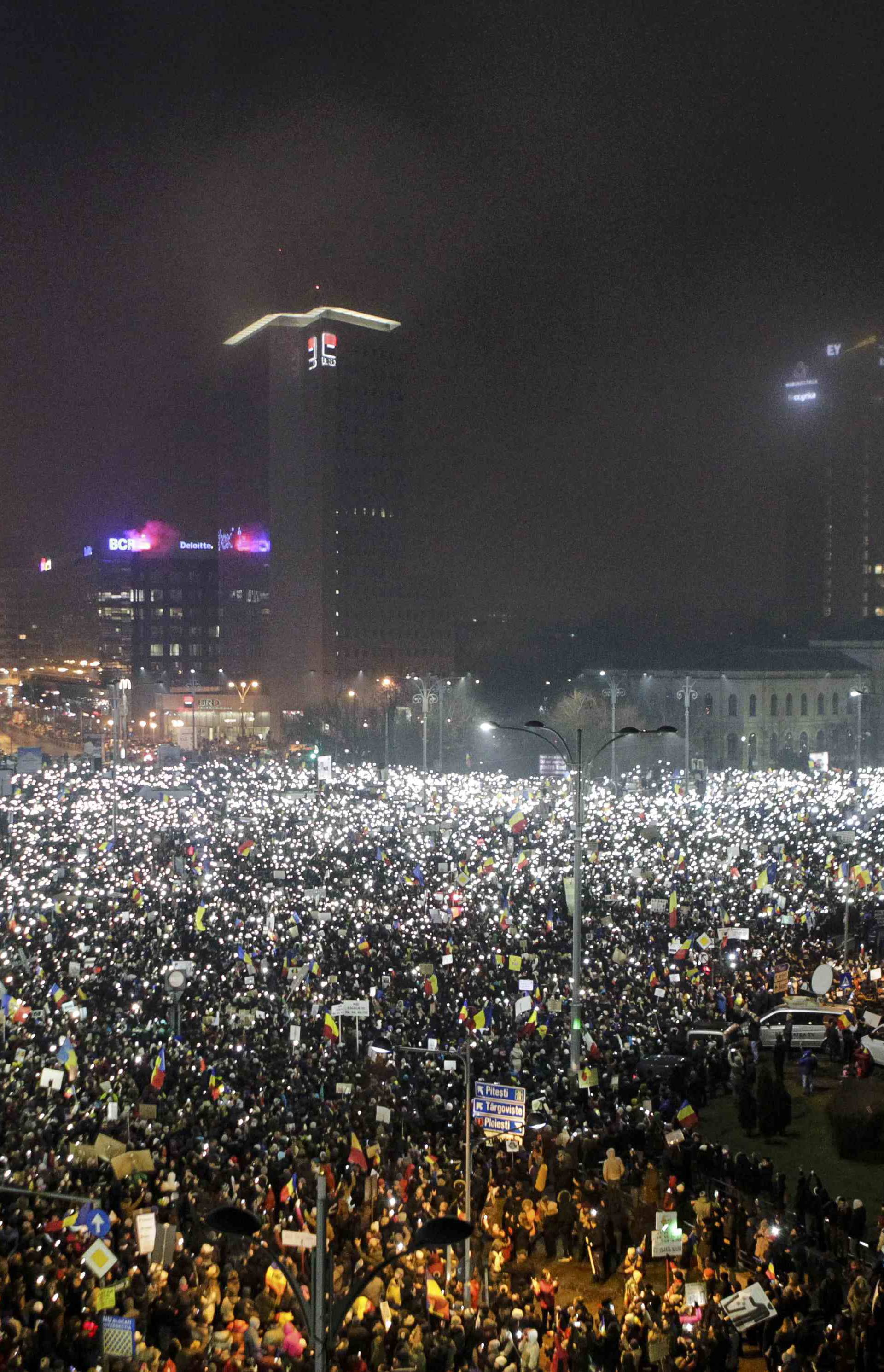 Protesters use phones and flashlights during a protest in Victoriei Square, in Bucharest, Romania