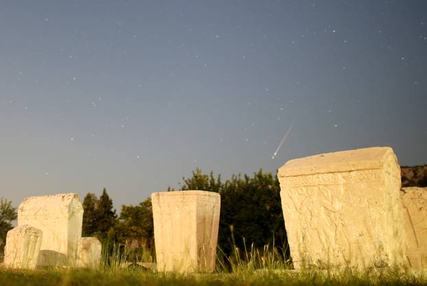A meteor streaks past stars in the night sky above medieval tombstones during the Perseid meteor shower in Radimlja near Stolac