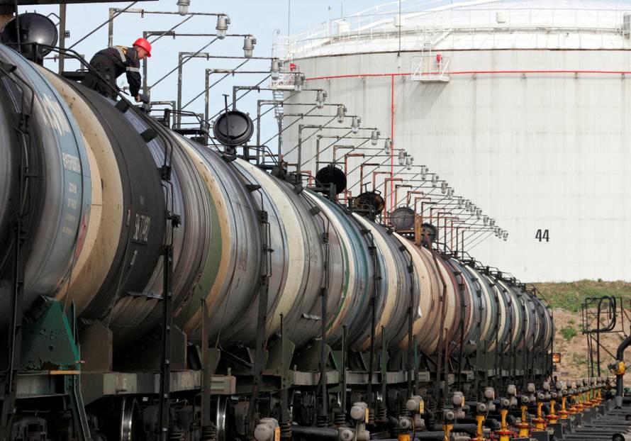 FILE PHOTO: A worker controls the freight level of a tanker wagon at the Rosneft oil terminal in Arkhangelsk
