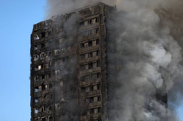 Smoke billows as firefighters tackle a serious fire in a tower block at Latimer Road in West London