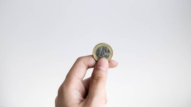 A,Hand,Holding,One,Euro,Coin,With,White,Background
