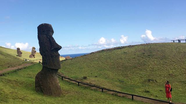 FILE PHOTO: A tourist looks at a statue named "Moai" at Easter Island