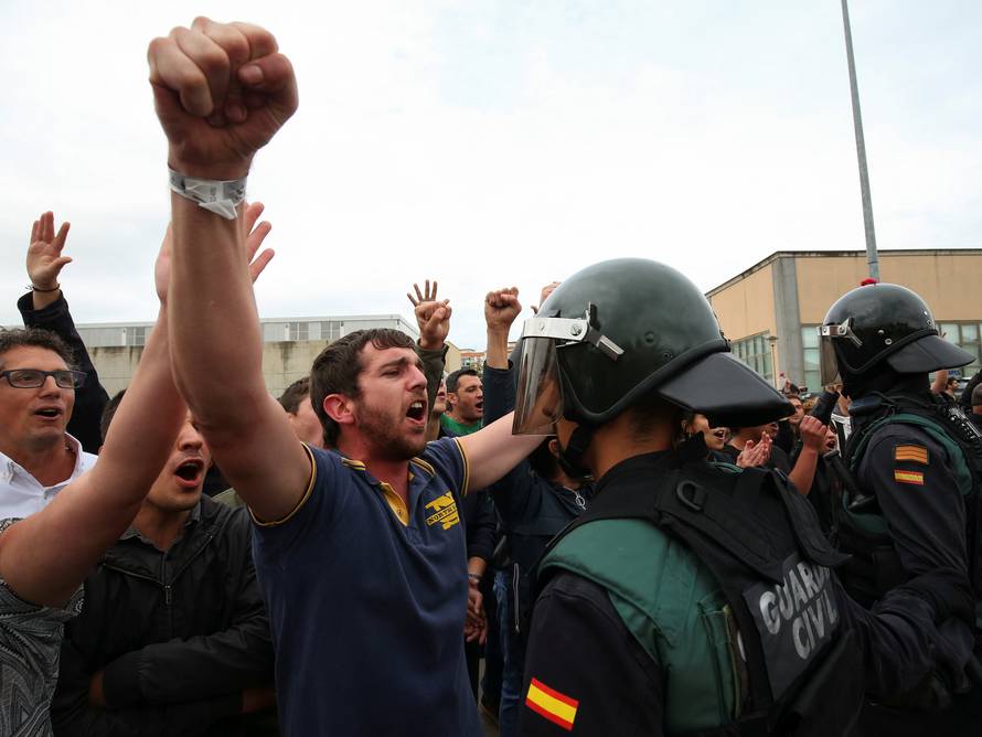 A man faces off with a Spanish Civil Guard officer outside a polling station for the banned independence referendum in Sant Julia de Ramis