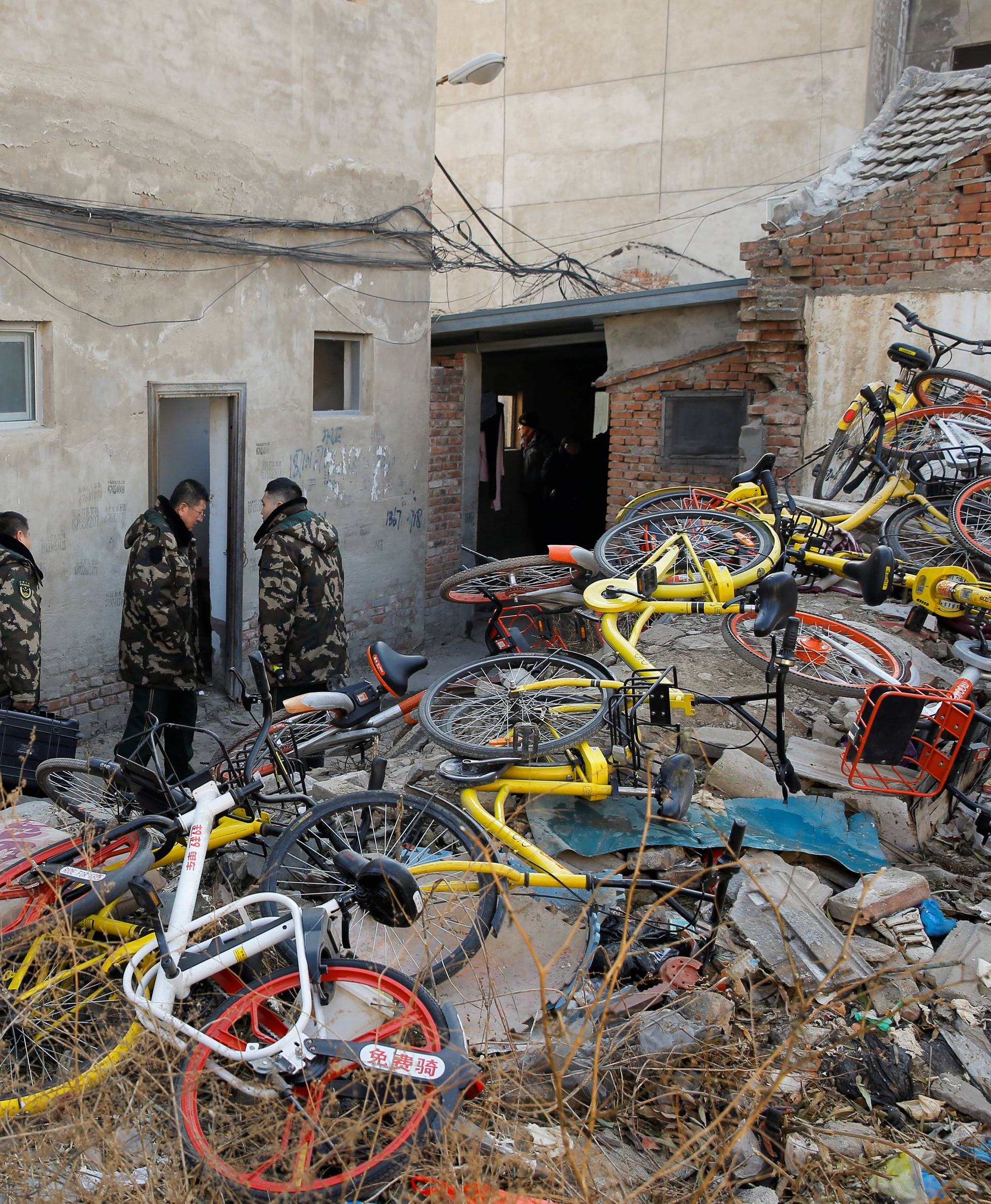 Investigators enter a house where a fire killed several people in Baiqiangzi village in Beijing