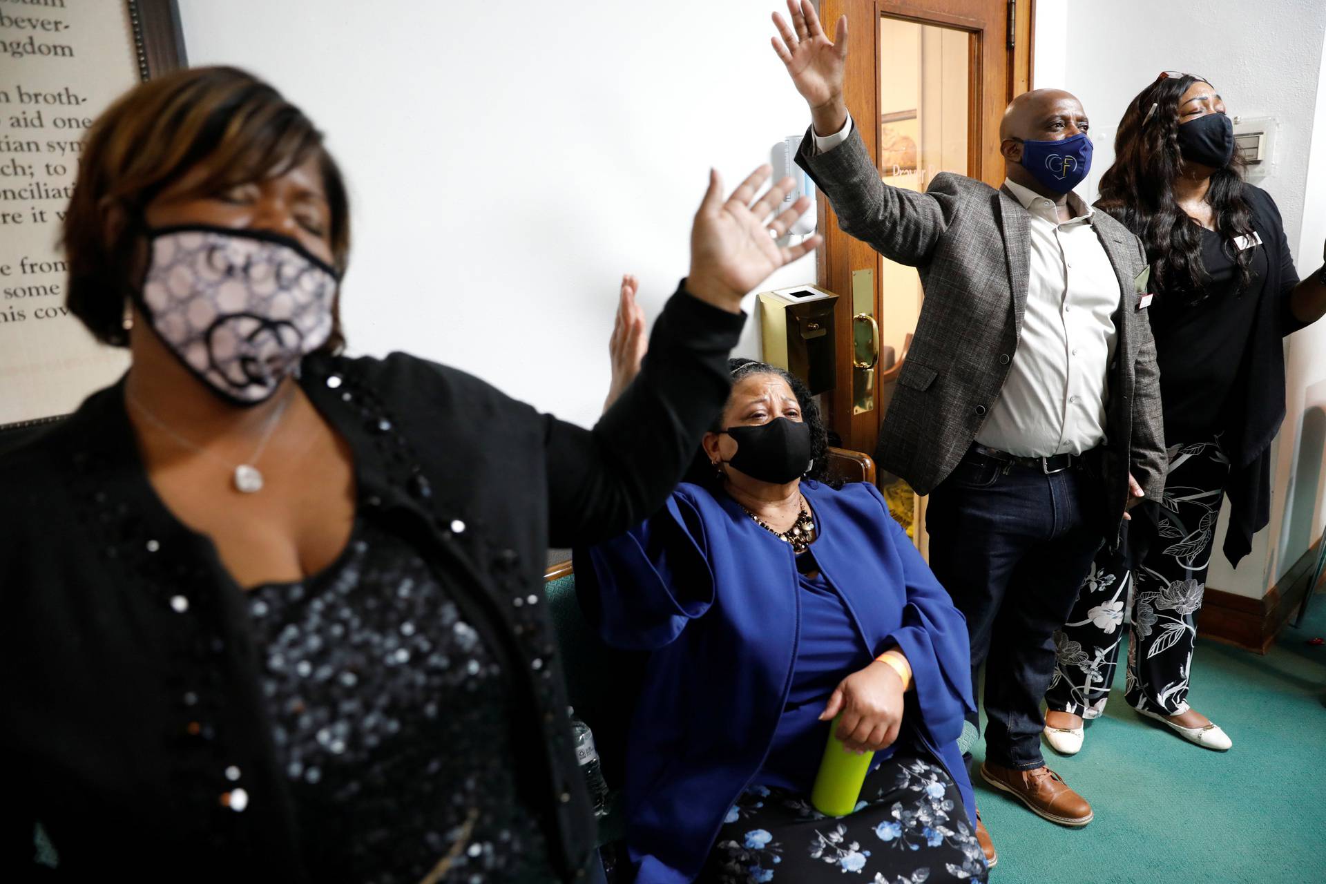 Greater Friendship Missionary Baptist Church members raise their hands in prayer during a vigil the day before opening statements in the trial of former police officer Chauvin, who is facing murder charges in the death of Floyd, in Minneapolis