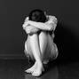 Sad woman sitting in the corner of a room