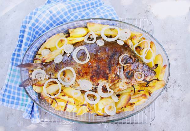 Baked carp with potatoes and onions