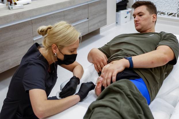 Former Ukrainian serviceman, who was wounded at a front line, comes to a clinic to treat scars, in Kyiv