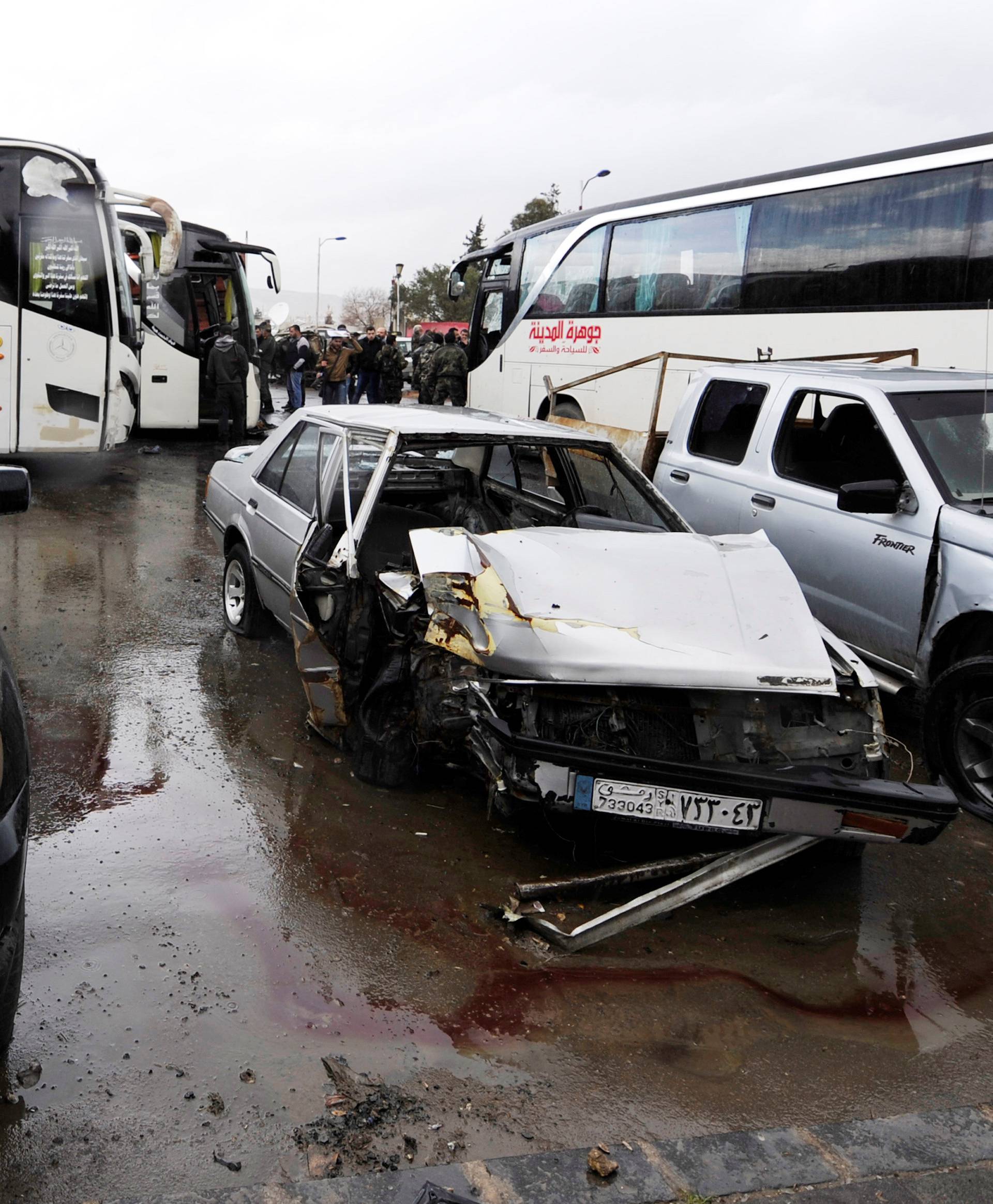 Damaged vehicles are pictured at the site of an attack by two suicide bombers in Damascus