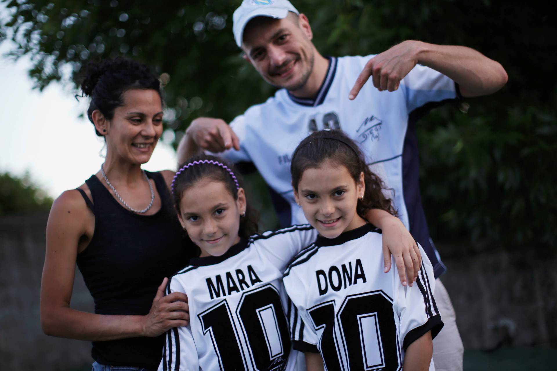 Walter Gaston Rotundo, a devoted Diego Maradona fan who named his twin daughters Mara and Dona after the soccer star, poses with his family in Buenos Aires