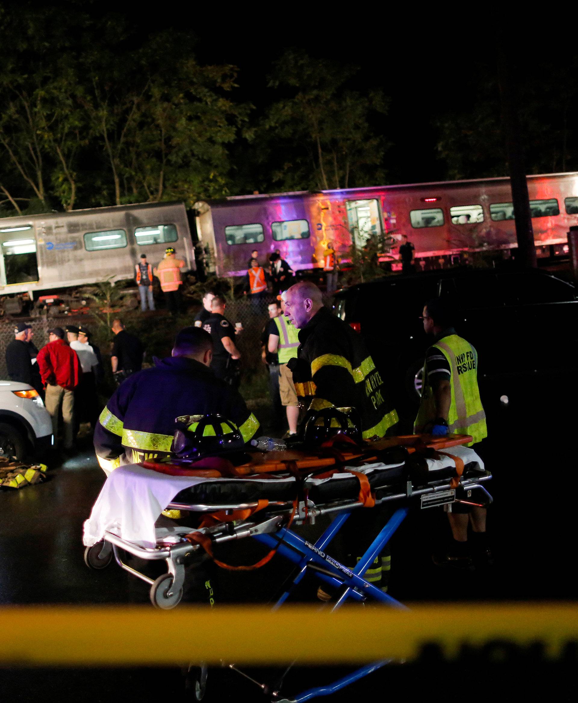 Emergency responders work near a train that sits derailed near the community of New Hyde Park on Long Island in New York