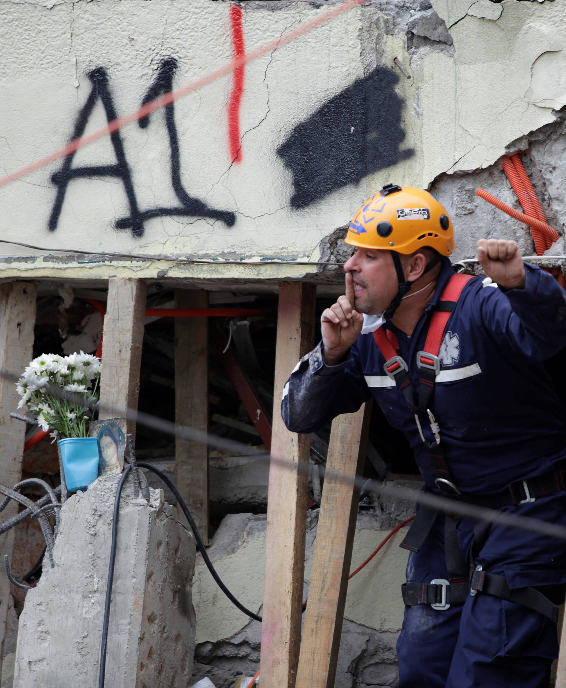 A paramedic gestures during a search for students at the Enrique Rebsamen school after an earthquake in Mexico City