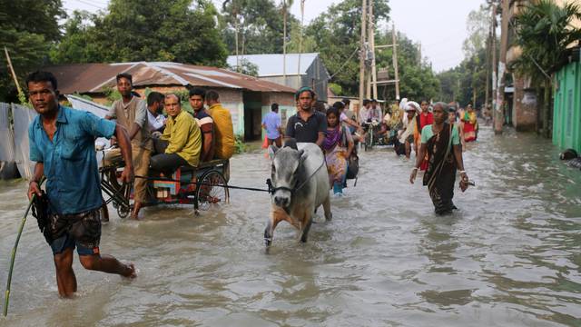 People move along a flooded road in Gaibandha