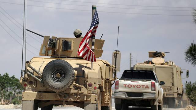 FILE PHOTO: The U.S. flag flutters on a military vehicle in Manbej countryside