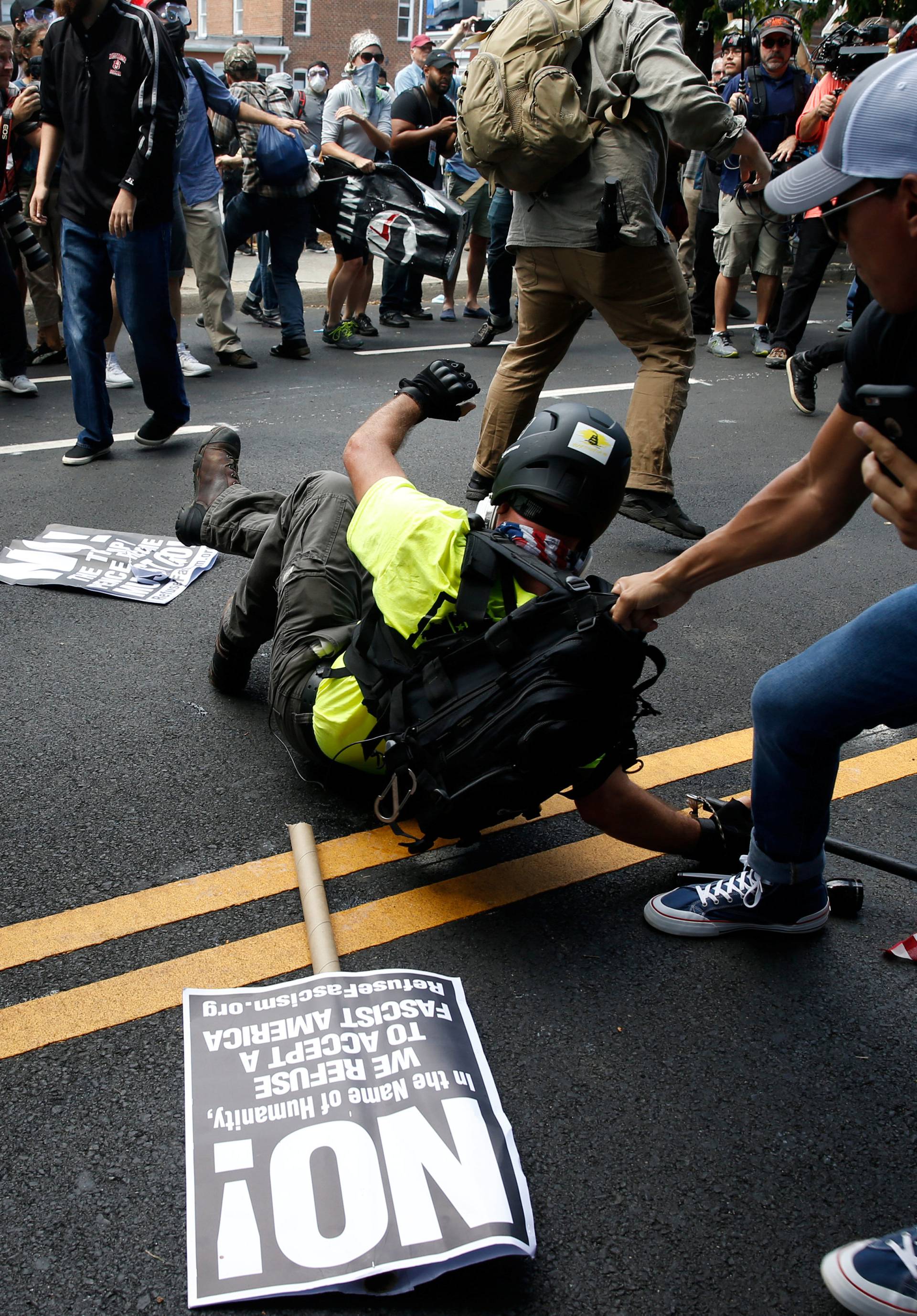 A man is pulled on after falling on the pavement during a clash between members of white nationalist protesters against a group of counter-protesters in Charlottesville