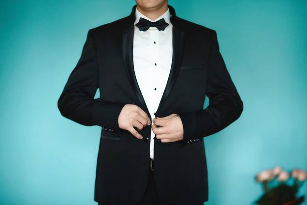 Grooms morning preparation, handsome groom getting dressed and preparing for the wedding