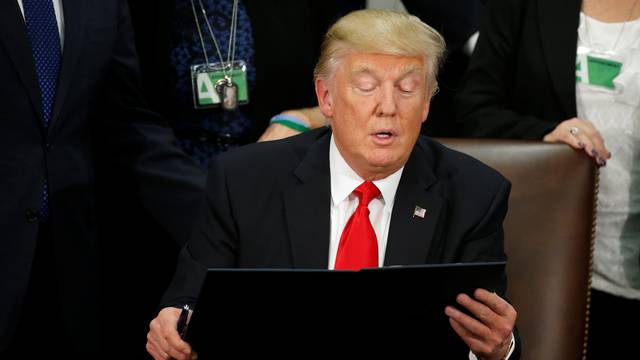 U.S. President Trump reads an executive order before signing it at Homeland Security headquarters in Washington