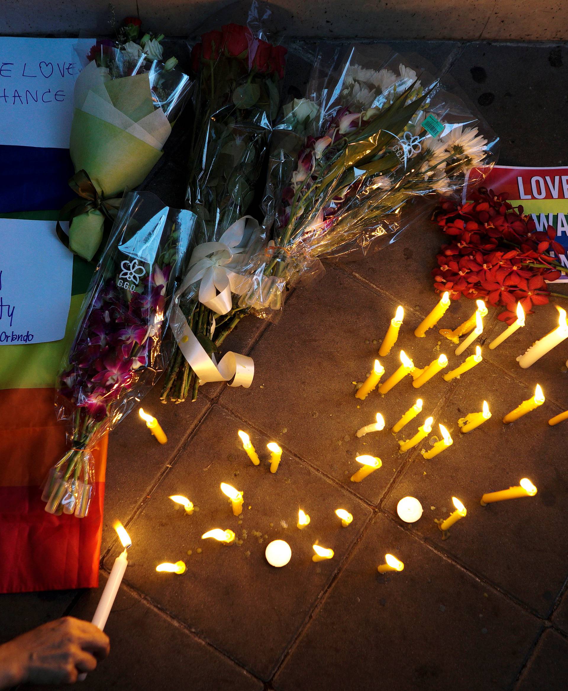 People attend a candlelight vigil in solidarity for the victims of the gay nightclub mass shooting in Orlando, at the U.S. Embassy in Bangkok