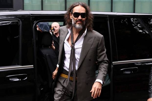 British actor and comedian Russell Brand arrives to stand trial on charges of rape and sexual assault, in London