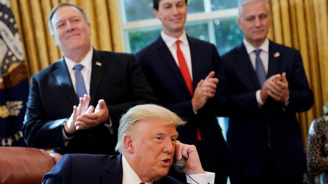 U.S. President Donald Trump is seen on the phone with leaders of Israel and Sudan  in the Oval Office at the White House in Washington