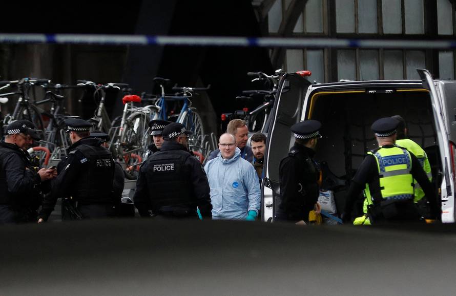 Police officers including one wearing a forensic suit, are seen in a cordoned off area at Waterloo station near to where a suspicious package was found, in London