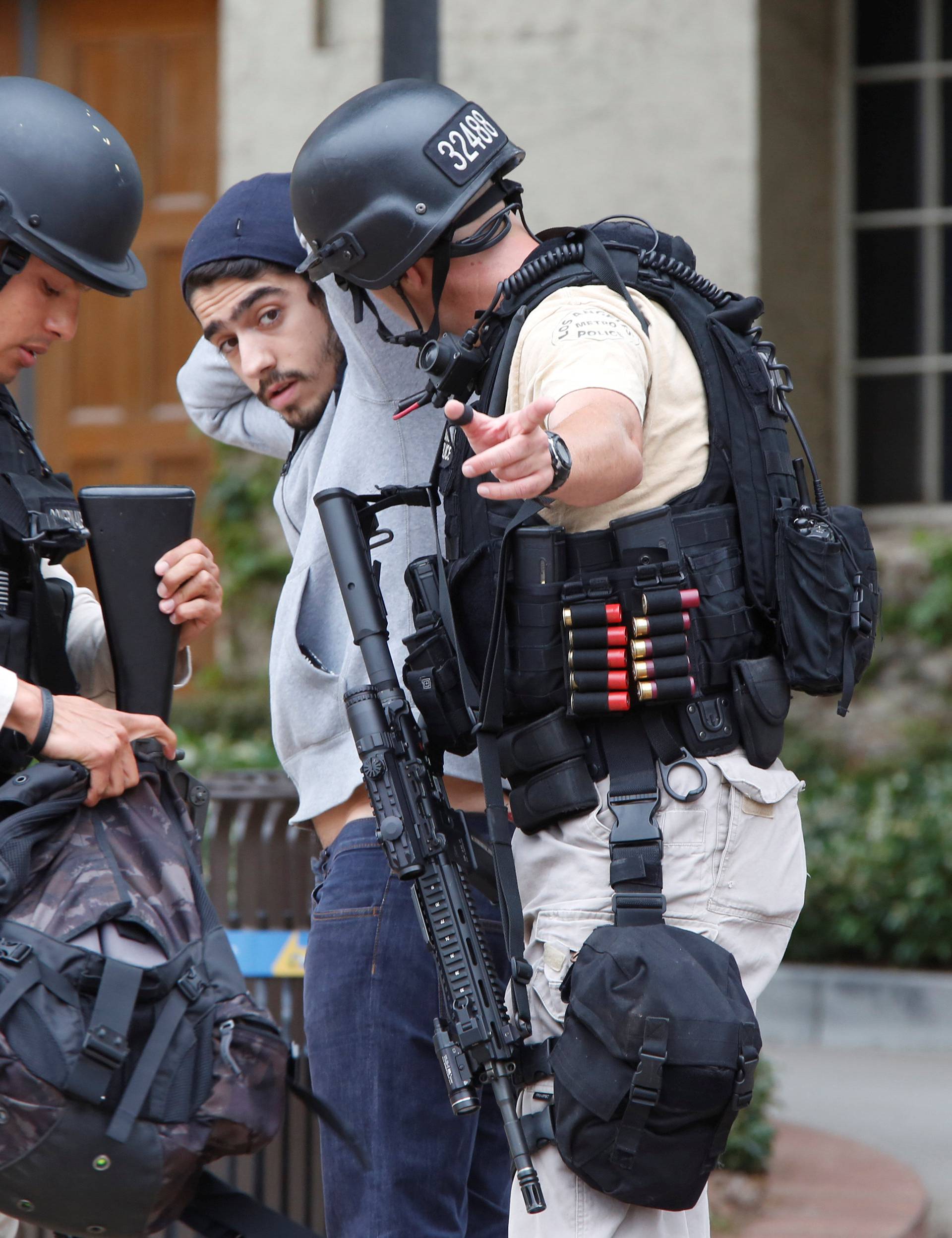 Police officers search a student's belongings at the University of California, Los Angeles (UCLA) campus after it was placed on lockdown following reports of a shooter in Los Angeles