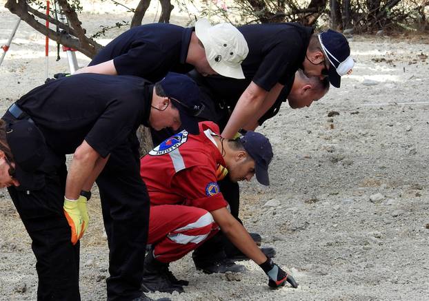 South Yorkshire police officers and members of the Greek rescue service (in red uniforms) investigate the ground before commencing excavating a site for Ben Needham, a 21 month old British toddler who went missing in 1991, on the island of Kos