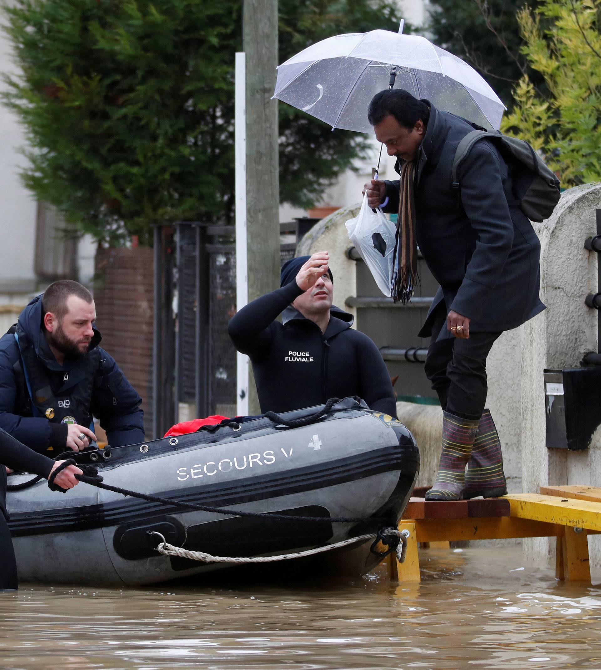 Paris police divers using a small boat patrol a flooded street of a residential area in Villeneuve-Saint-Georges