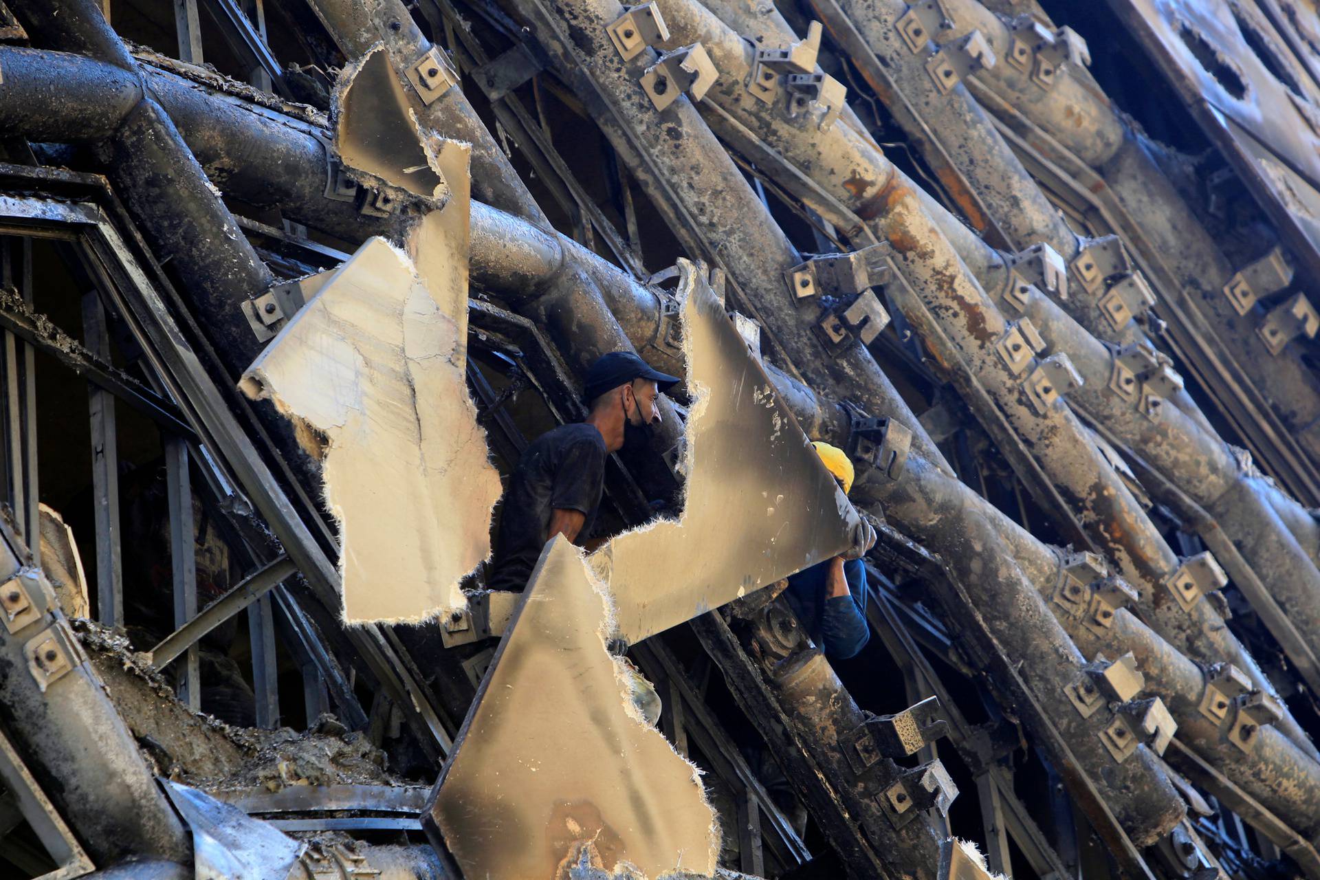 A man checks the damage after a fire erupted in a landmark building in Beirut's commercial district