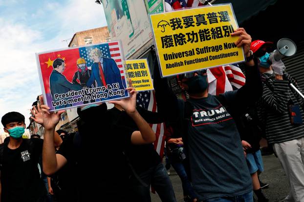 Anti-government protesters wave U.S. national flags as they march during anti-parallel trading protest at Sheung Shui, a border town in Hong Kong