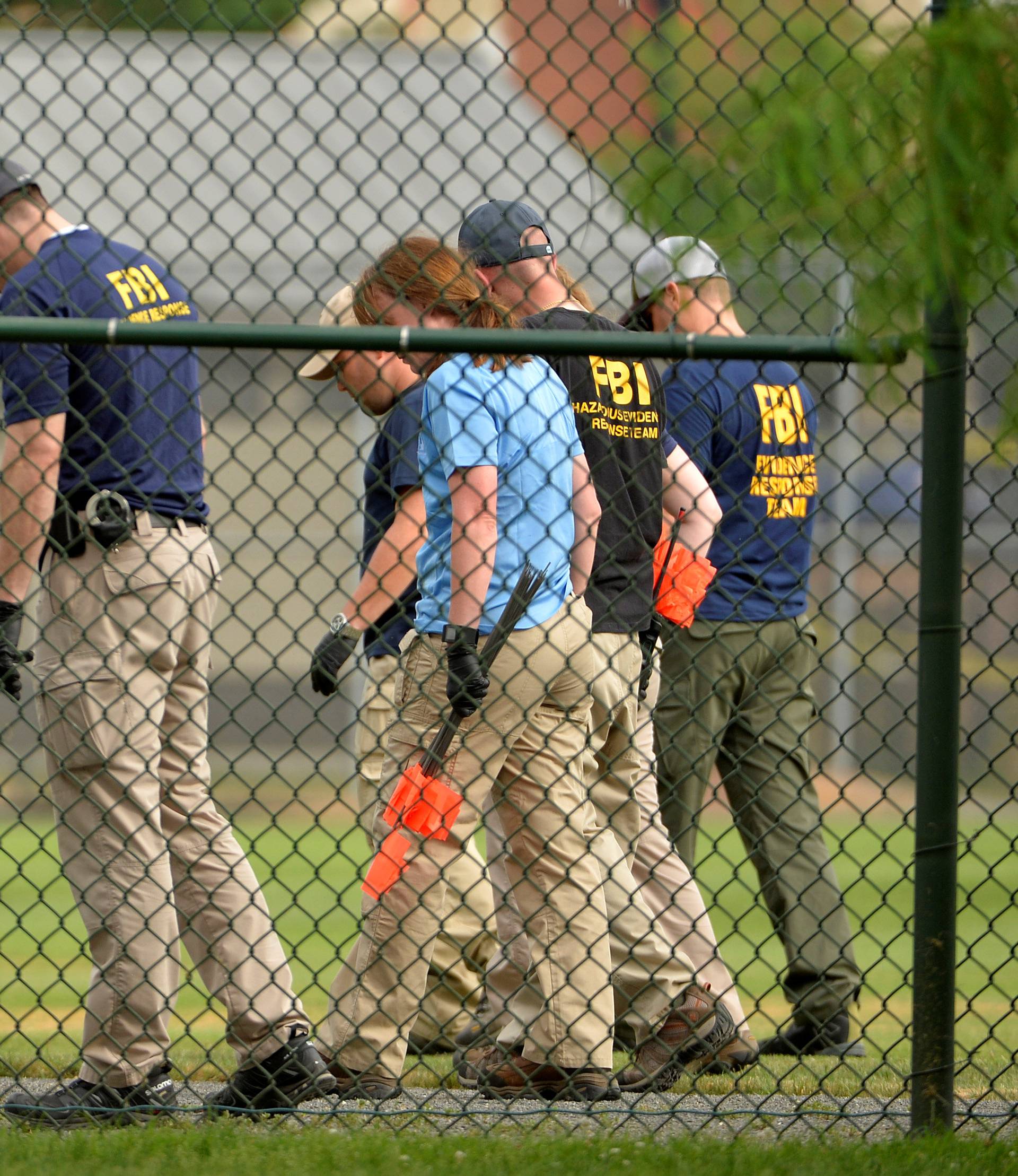 FBI technicians examine playing field at scene of shooting of Congressional baseball practice