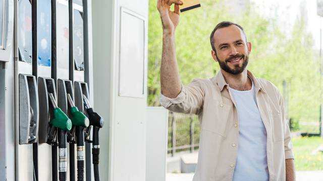 Happy,Bearded,Man,Holding,Credit,Card,And,Smiling,At,Gas