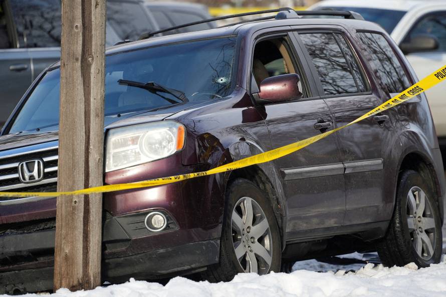 Members of U.S. Immigration and Customs Enforcement (ICE) stand guard after a driver of a vehicle was shot in Minneapolis