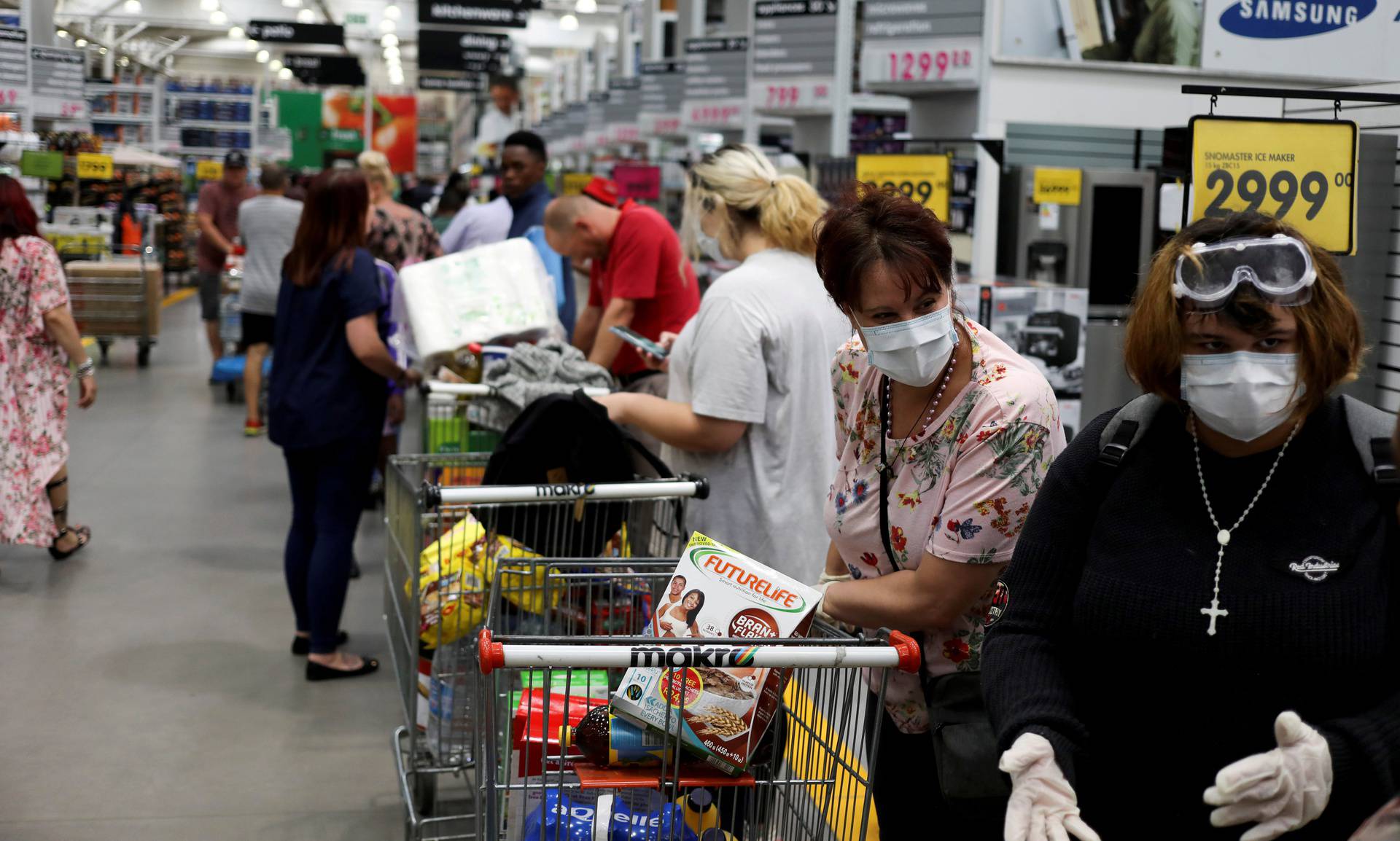 FILE PHOTO: Shoppers stock up on groceries as they wear protective masks to contain coronavirus at a Makro store in Johannesburg