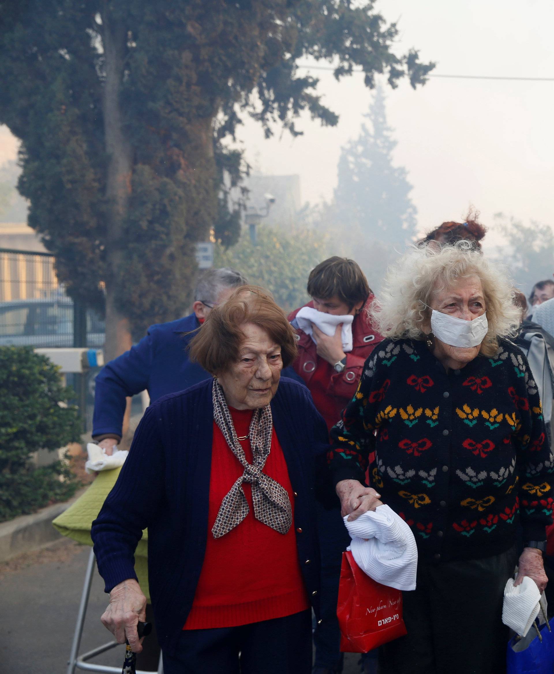 Emergency personnel evacuate elderly people as a wildfire rages in the northern city of Haifa, Israel