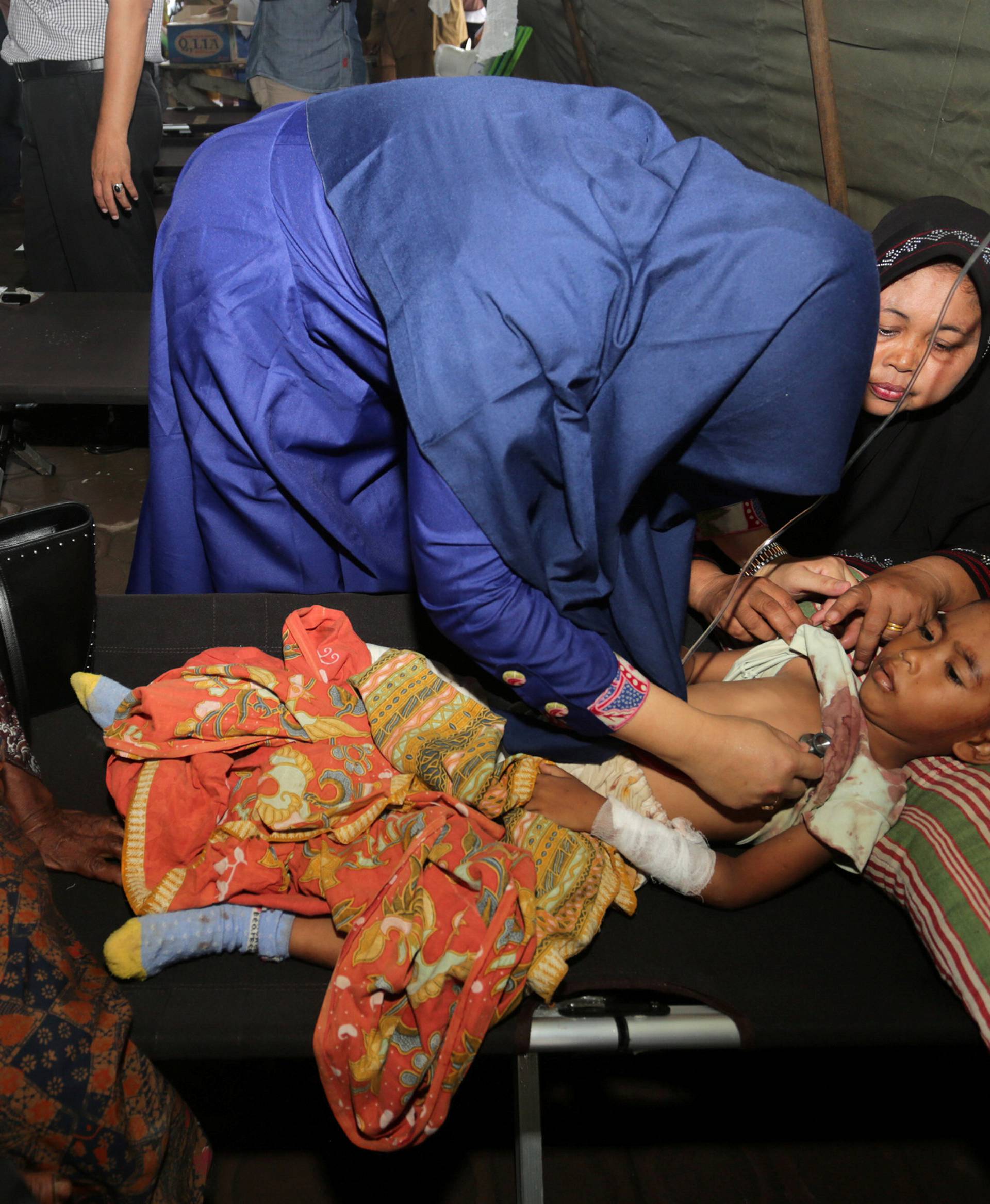 A medical officer checks the condition of an injured child at a hospital following an earthquake in Sigli, Pidie regency, in the northern province of Aceh