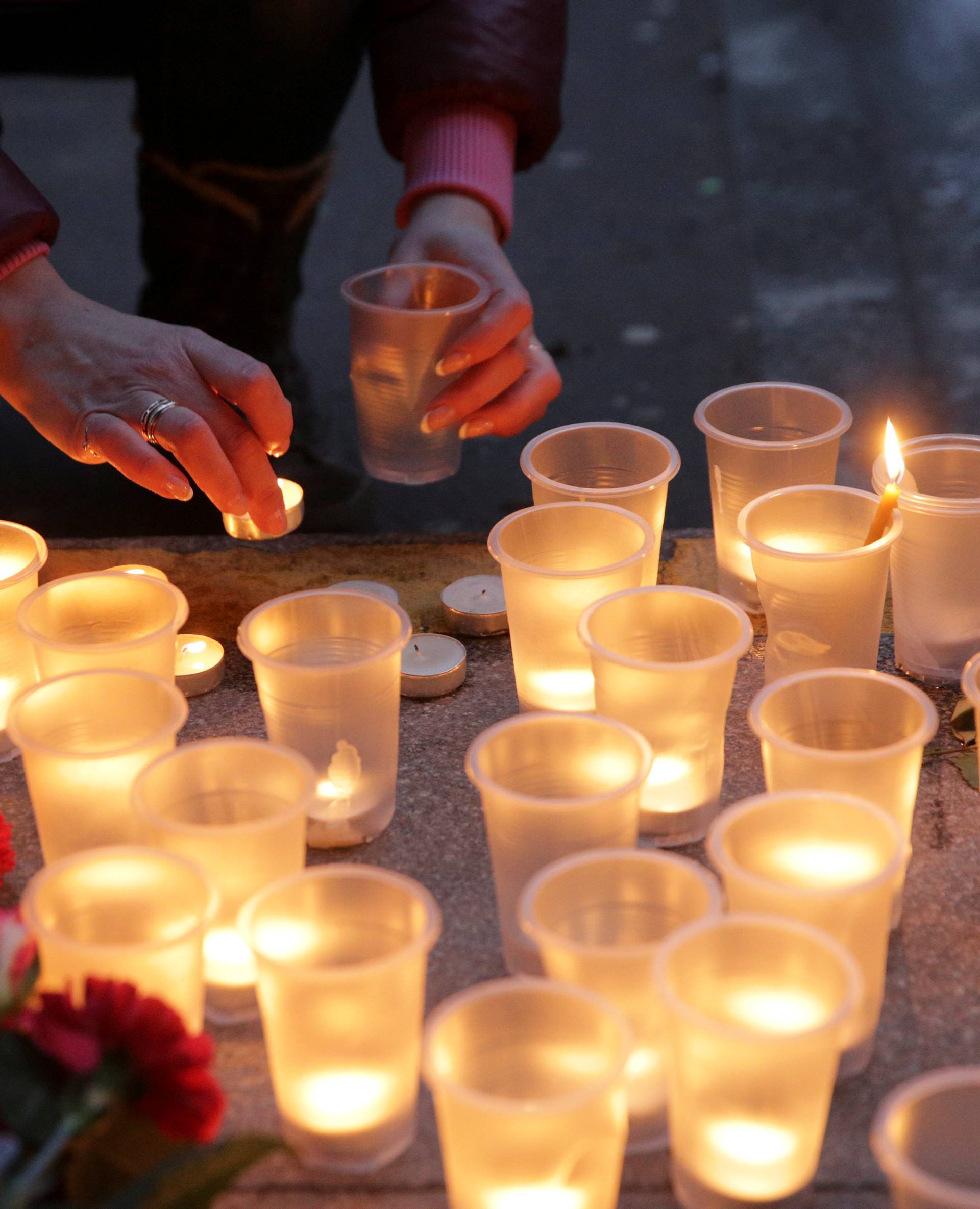 A woman leaves a candle during a memorial service for victims of a blast in St.Petersburg metro, outside Spasskaya metro station in St. Petersburg