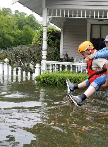 Handout photo of a Texas National Guard soldier carries a woman on his bank as they conduct rescue operations in flooded areas around Houston