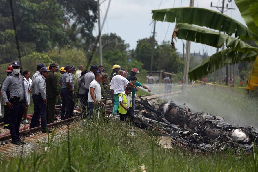 Rescue team members work in the wreckage of a Boeing 737 plane that crashed in the agricultural area of Boyeros