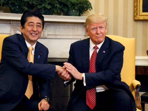 Japanese Prime Minister Abe shakes hands with U.S. President Trump during their meeting in the Oval Office at the White House in Washington