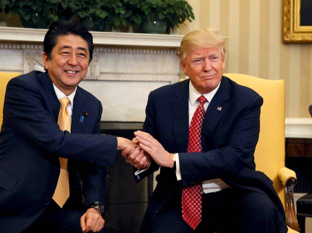 Japanese Prime Minister Abe shakes hands with U.S. President Trump during their meeting in the Oval Office at the White House in Washington